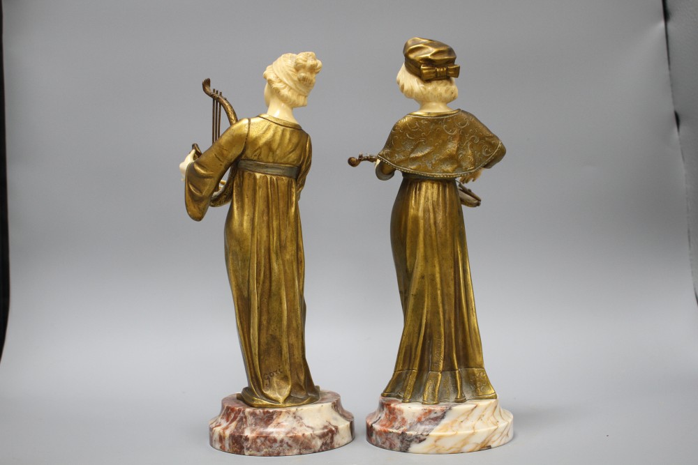 A pair of Alphonse Gori ivory and ormolu figures of medieval musicians, girl playing an Irish harp, the other plucking a violin, on mar